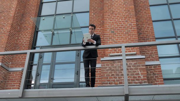 Young Businessman Using Tablet Outside Loft Office - Photo, Image