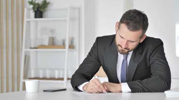 Businessman Writting Documents in Office - Фото, изображение