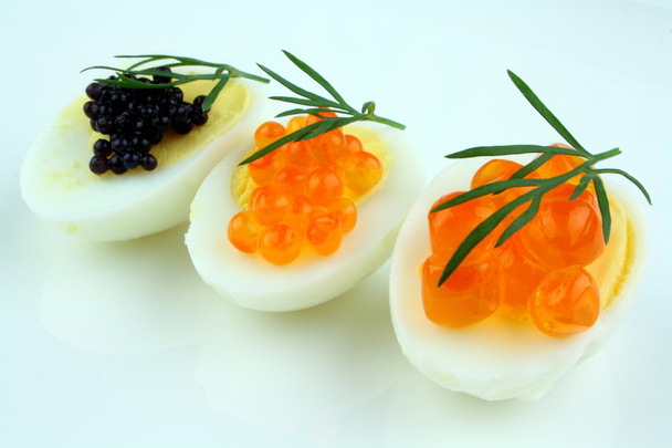 Trout, salmon and sturgeon caviar served on quail eggs - Photo, Image