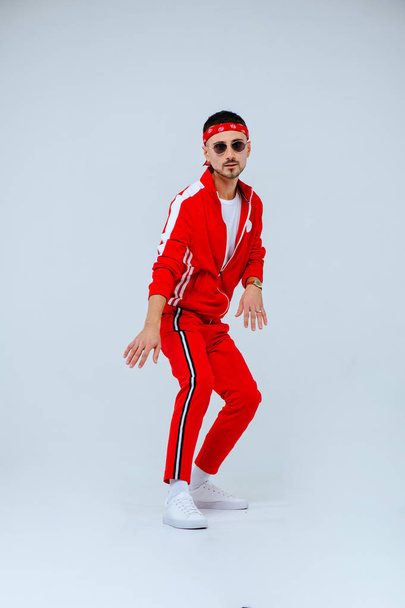 Здоровье, веселье, спорт для людей - счастливый молодой человек в красном спортивном костюме на белом фоне
. - Фото, изображение