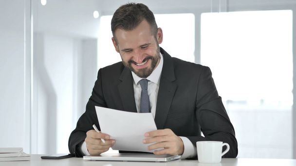 Excited Businessman Celebrating Success while Reading Documents - Photo, Image