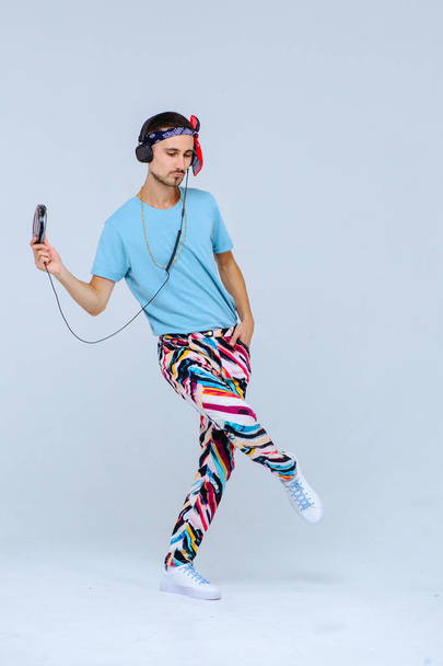 fashionable bright man in headphones in retro style manifestation of emotions of joy, gestures with hands space for text. - Photo, Image