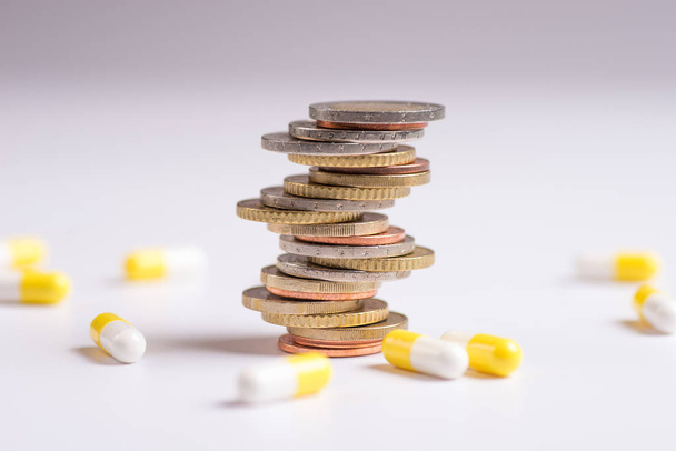 Coins are placed among themselves in different positions next to the pills. Copy space for text - Fotoğraf, Görsel