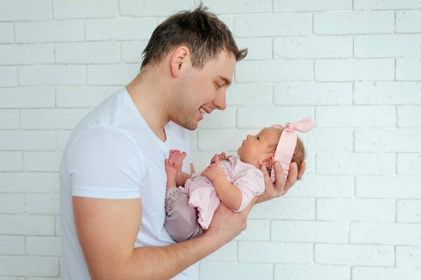 Close-up πορτρέτο της ευτυχισμένος νέος πατέρας αγκάλιασμα και το φίλημα του γλυκό αξιολάτρευτο παιδί νεογέννητο. Ευτυχισμένη οικογένεια έννοια. Όμορφη εννοιολογική εικόνα της μητρότητας - Φωτογραφία, εικόνα