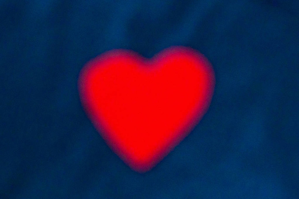 Fondos del Día de San Valentín. Fondo azul brillante con San Valentín. Fondos con corazones. Corazón rojo sobre un fondo azul brillante en el centro. Ahorro de fondo para el Día de San Valentín, el efecto de desenfoque
 - Foto, imagen