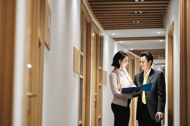 Empresária explicando documentos para cliente chinês feliz no escritório do banco
 - Foto, Imagem