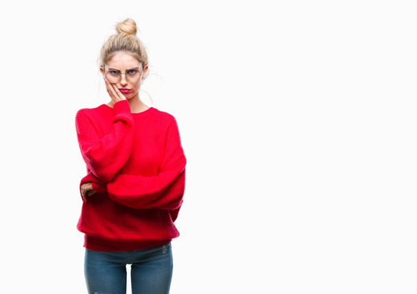 Jonge mooie blonde vrouw dragen rode trui en glazen over geïsoleerde achtergrond denken op zoek moe en verveeld met depressie problemen met gekruiste armen. - Foto, afbeelding