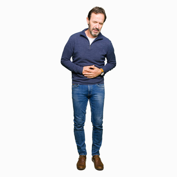 Knappe man van middelbare leeftijd, dragen een trui met de hand op de maag omdat indigestie, pijnlijke ziekte onwel. Ache concept. - Foto, afbeelding