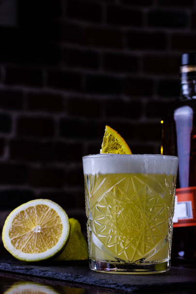 A classic recipe for whiskey sour - with bourbon, cane syrup and lemon juice, garnished with orange. Traditional aperitif. Space for text - Zdjęcie, obraz