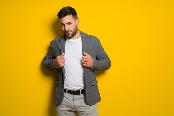 Jeune bel homme posant et modelant sur fond jaune isolé
 - Photo, image