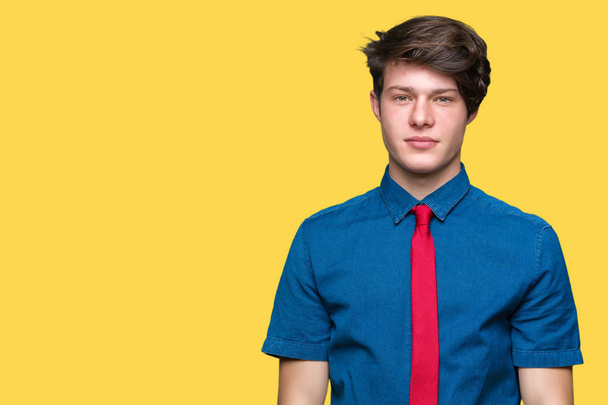 Mladý pohledný obchodní muž nosí červenou kravatu izolované pozadí s vážným výrazem na tváři. Jednoduché a přirozené, při pohledu na fotoaparát. - Fotografie, Obrázek