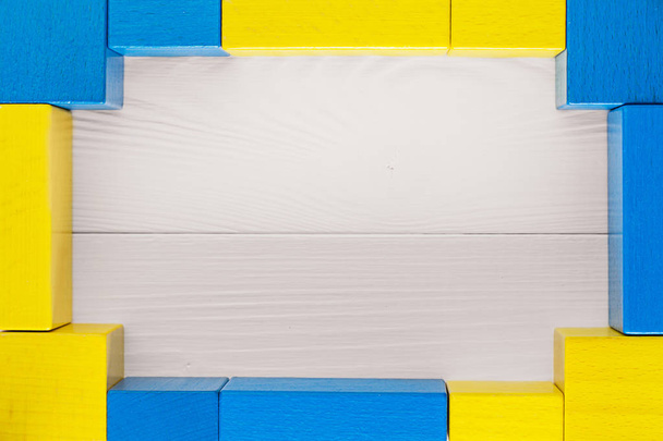 Wooden two-tone frame. Yellow blue frame on a white wooden background, with space for text. Colorful background with copy space. - 写真・画像