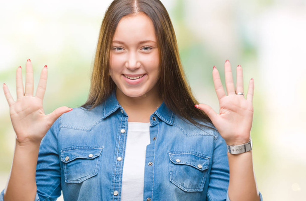 Young caucasian beautiful woman over isolated background showing and pointing up with fingers number ten while smiling confident and happy. - Foto, afbeelding