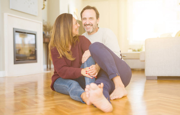 Beautiful romantic couple sitting together on the floor at home - Foto, Imagem
