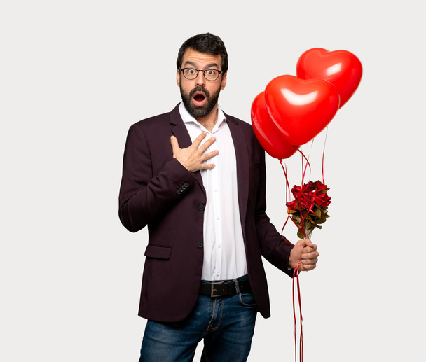 Man in valentine day surprised and shocked while looking right over isolated grey background - Foto, Imagen