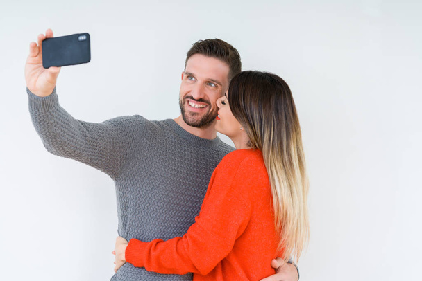 Beautiful young couple in love, kissing and hugging each other taking a selfie picture - Fotografie, Obrázek