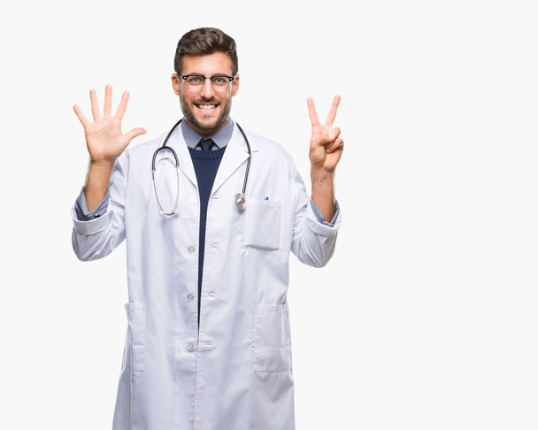 Young handsome doctor man over isolated background showing and pointing up with fingers number seven while smiling confident and happy. - Photo, Image