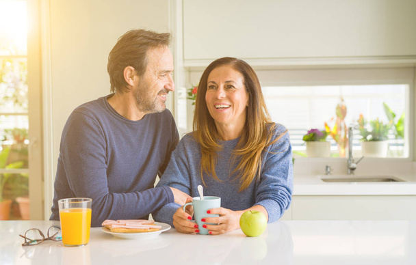 朝自宅で健康的なスタイルの朝食を持っている美しいロマンチックな中年カップル - 写真・画像