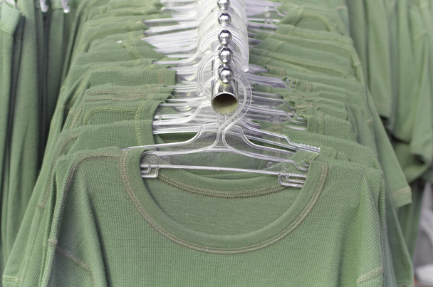 πράσινα ρούχα σε κρεμάστρες - Φωτογραφία, εικόνα