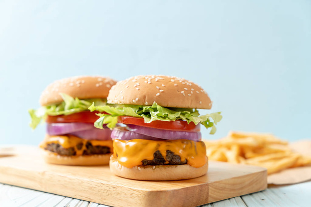 fresh tasty beef burger with cheese and french fries on wood background - Valokuva, kuva