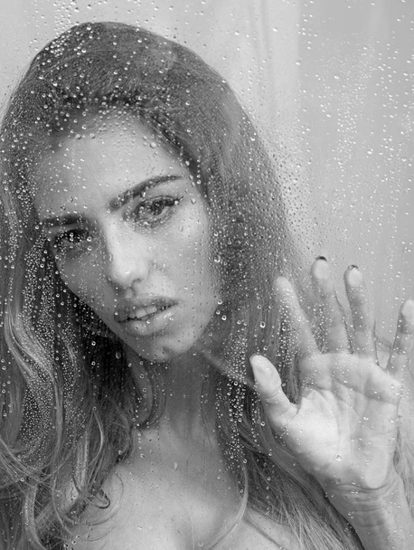 Рука молодої жінки меланхолії і сумно біля вікна під дощем
. - Фото, зображення