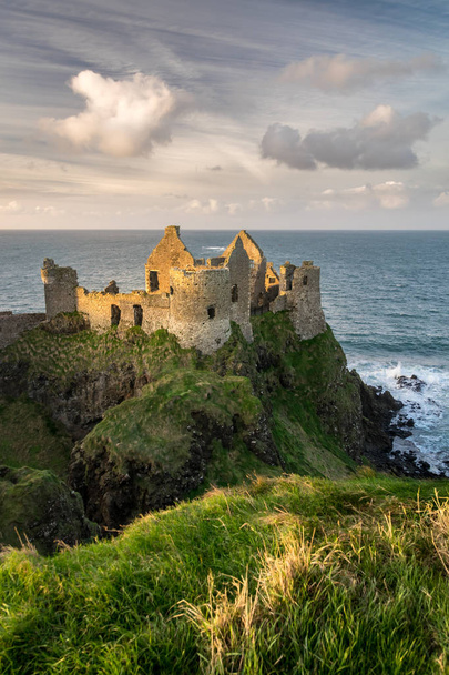 これは北アイルランドのダンルース城の遺跡の写真です。それは 13 世紀に大西洋を見渡す海崖の上に建てられました。 - 写真・画像