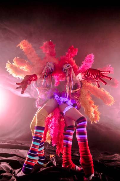 young can-can dancers with pom-poms posing together in carnival concept against misty background - Foto, imagen