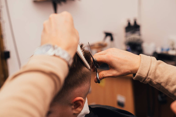 cropped image of barber making haircut of little boy at salon - Foto, Imagem
