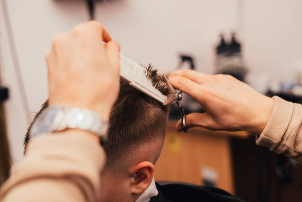 cropped image of barber making haircut of little boy at salon - Фото, зображення