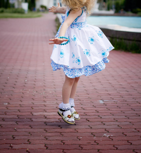 klein meisje springen in de straat - Foto, afbeelding