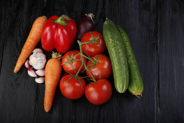 Closeup of assorted vegetables over dark wooden background  - 写真・画像