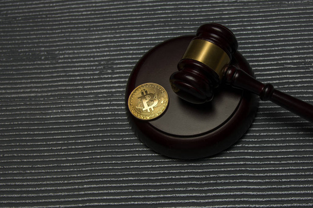  golden bitcoin lie on wooden pedestal with judge gavel - Valokuva, kuva