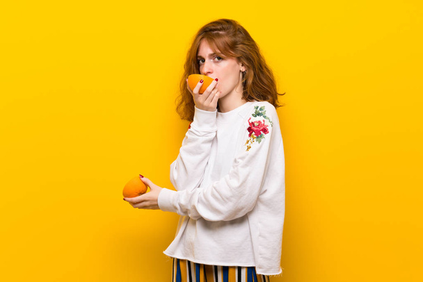 Ruda młoda kobieta z plastry pomarańczy - Zdjęcie, obraz