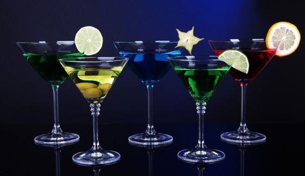 Alcoholic cocktails in martini glasses on dark blue background - Photo, Image