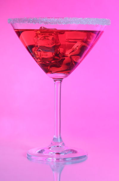 Red cocktail in martini glass on pink background - 写真・画像