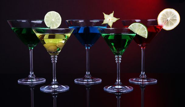 Alcoholic cocktails in martini glasses on dark red background - Photo, Image