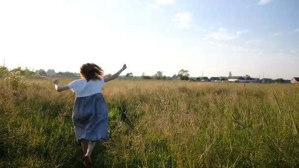 Frau im komischen Kleid läuft bei Sonnenuntergang auf einem Feld davon, Zeitlupe und Kamerafahrt - Filmmaterial, Video