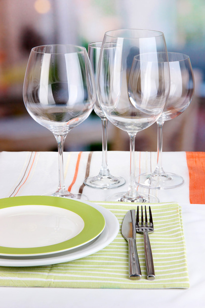 Table setting with glasses for different drinks on table on room background - Foto, imagen
