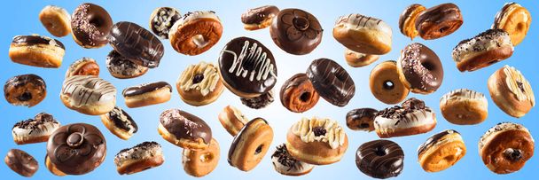 Meerdere donuts op blauwe achtergrond. Afbeelding met hoge resolutie voor de voedingsindustrie. - Foto, afbeelding
