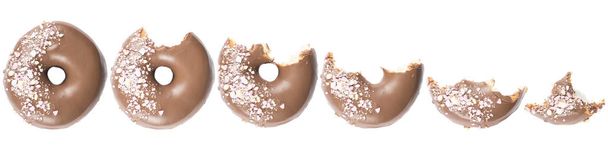 Doghnut glacé au chocolat avec des bonbons saupoudrés sur le dessus sur fond blanc. Image haute résolution pour l'industrie alimentaire
. - Photo, image