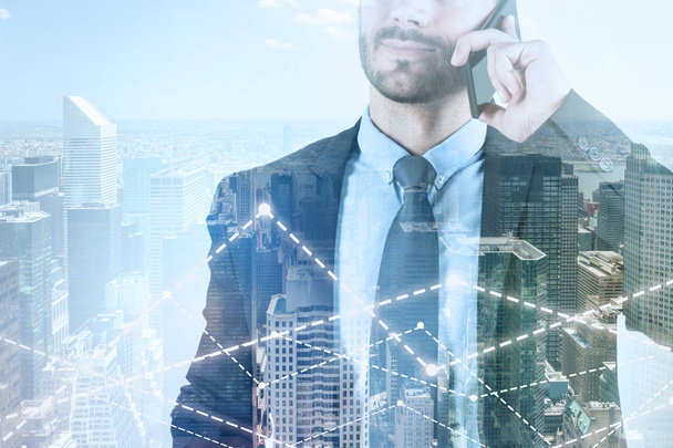 Unrecognizable bearded businessman talking on smartphone standing over cityscape background with double exposure of graphs. Toned image. Stock market concept - Fotó, kép