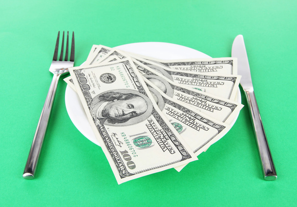 Money on plate on green background - Фото, изображение