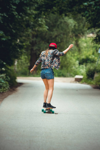 young beautiful fit  woman on skateboard in park - Foto, afbeelding