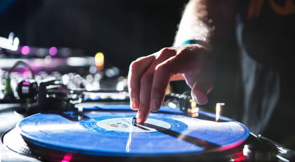 KIEV - 4 JULY, 2018: Hand of Dj DOC playing music with retro Technics SL 1210 turntables in night club.Professional audio equipment for night club party.Concert stage turn table player in use - Fotografie, Obrázek