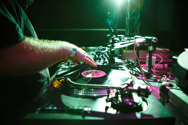 KIEV-4 JULY,2018: Concert dj plays music.Disc jockey scratches old analog vinyl record with musical tracks on hip hop party in night club - Fotó, kép