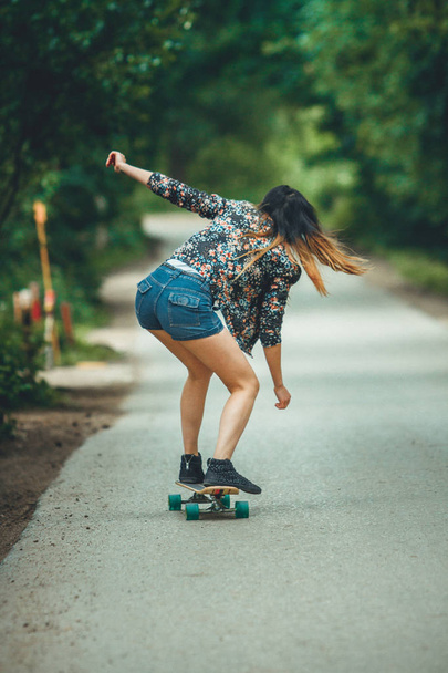young beautiful fit  woman on skateboard in park - Fotó, kép