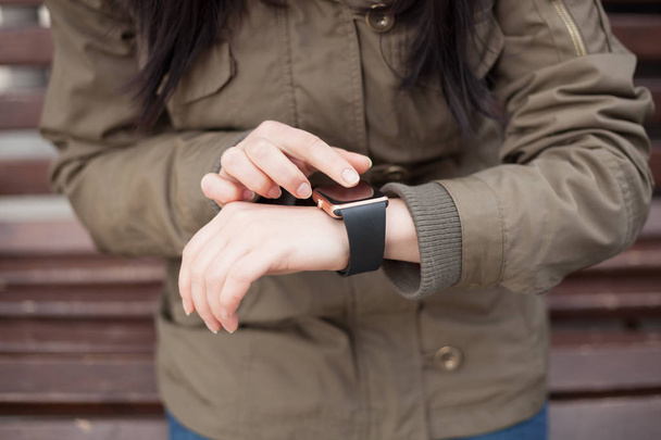 Hands of a woman using her trendy smart watch. This new gadget lets you always stay connected to internet and social media networks from anywhere you want. - 写真・画像