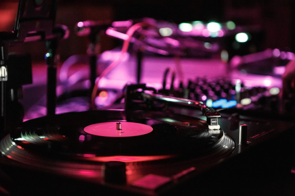 KIEV-4 JULY,2018: Technics turntable player plays old analog vinyl record with techno music at festival in night club.Professional disc jockey audio equipment for playing electronic musical tracks - Foto, Imagen