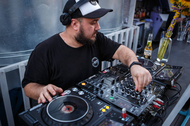 KIEV -10 JULY, 2018: DJ Panchez in headphones plays musical set in party bar. - Foto, imagen