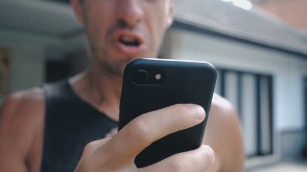 Hombre enojado usando Smartphone. Furioso hombre gritando con teléfono inteligente en la mano
 - Imágenes, Vídeo